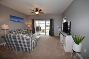 a living room with a couch and a tv at 113 Cypress Bend Condo in North Myrtle Beach