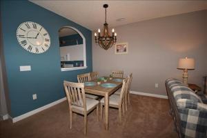 a dining room with a table and a clock on the wall at 113 Cypress Bend Condo in North Myrtle Beach
