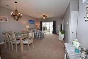 a dining room and living room with a table and chairs at 113 Cypress Bend Condo in North Myrtle Beach
