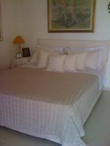 a bedroom with a large white bed with pillows at Nerantza Villa Jolimax in Nerátza