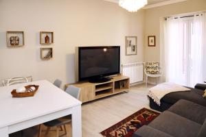 sala de estar con TV de pantalla plana y sofá en Cal Sisquet - LOLA en La Seu d'Urgell