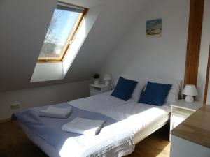 a bedroom with a bed with blue pillows and a window at Apartament Pola & Tola in Sopot