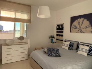 馬里納－迪拉古薩的住宿－Blue Beach House，一间卧室配有一张床、一个梳妆台和一扇窗户。