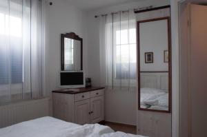 ein Schlafzimmer mit einem Bett, einem Spiegel und einem TV in der Unterkunft Haus Ostseestrand in Ahlbeck