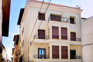 - un bâtiment blanc avec balcon dans une rue dans l'établissement Cal Sisquet - LOLA, à La Seu d'Urgell