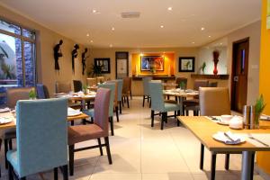 a dining room with tables and chairs in a restaurant at La Cour Hotels and Apartments Cooper in Lagos