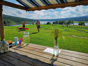 a picnic table with a view of a field with people flying kites at Skatauddens Lantgård in Älvsbyn