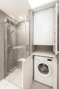 a bathroom with a washing machine and a shower at Super-Apartamenty Love Deluxe in Poznań