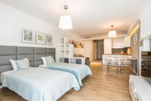two beds in a room with a kitchen at Super-Apartamenty Love Deluxe in Poznań