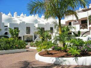 a white building with a palm tree in front of it at Apartment luxury complex near the sea in Adeje