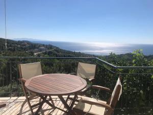 a table and chairs on a balcony with the ocean at Aegean Breeze Mansion in Kymi +12 photos