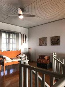 a living room with a couch and a ceiling fan at Aegean Breeze Mansion in Kymi