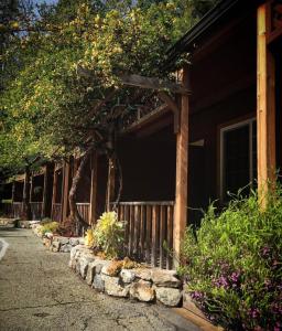a house with a fence and some trees and flowers at Big Sur River Inn in Big Sur