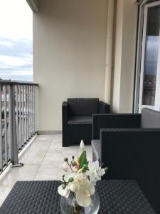 un vase de fleurs sur une table sur un balcon dans l'établissement Roanne-centre appartement, à Roanne