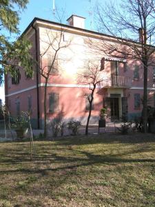 um grande edifício rosa com árvores em frente em B & B le querce di Marco CAMERA VERDE em San Prospero 