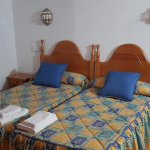 a bedroom with a bed with blue pillows at Casa Rural Pocotrigo in Linares