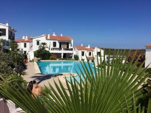 a woman sitting next to a swimming pool in a house at Duplex Son Parc Best Sea Views in Son Parc