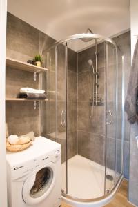 W łazience znajduje się kabina prysznicowa i pralka. w obiekcie Krasickiego 14 w mieście Gdynia