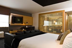 1 dormitorio con 1 cama grande y TV de pantalla plana en Ramada Plaza by Wyndham Prince George, en Prince George