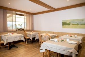 a restaurant with four tables with white table cloth at Pension An Der Linde in Lagundo