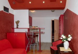 a living room with red furniture and a bar at Apartments Skadarlija in Belgrade