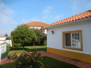 a white house with a window and a yard at Casa AMOReira de Óbidos in Amoreira