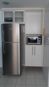 a kitchen with a stainless steel refrigerator and a microwave at Bacutia Frente Mar in Guarapari
