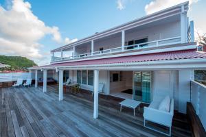 una casa con una gran terraza con sillas. en Penthouse de Luxe Gustavia, en Gustavia