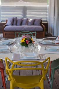 a table with a yellow chair and a table with flowers on it at Penthouse de Luxe Gustavia in Gustavia