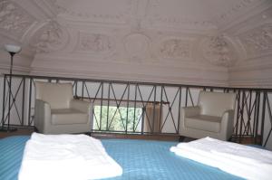 カターニアにあるアパルタメンティ ヴィラ ベリーニのベッドルーム1室(椅子2脚、ベッド1台付)