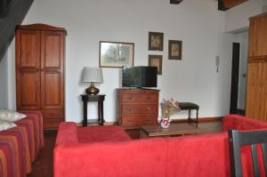 sala de estar con sofá rojo y TV en Appartamenti Villa Bellini, en Catania