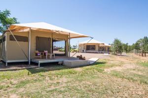 une maison avec une tente dans un champ dans l'établissement Dubbo Rhino Lodge, à Dubbo
