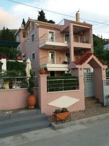 une maison rose avec des plantes devant elle dans l'établissement Themis Apartments, à Sami