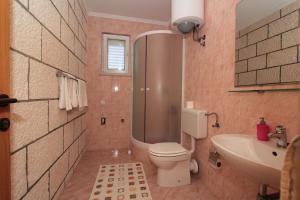 Un baño con inodoro, ducha y lavabo. en Guesthouse Victoria, en Dubrovnik 35 fotos más