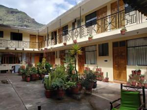 a building with potted plants in a courtyard at Hospedaje Inti in Pisac