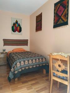 een slaapkamer met een bed en een houten vloer bij Hospedaje Inti in Pisac