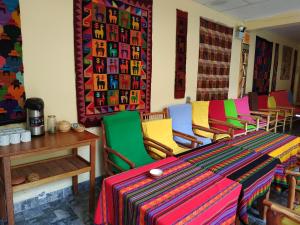 Habitación con sillas coloridas y mesa. en Hospedaje Inti en Pisac