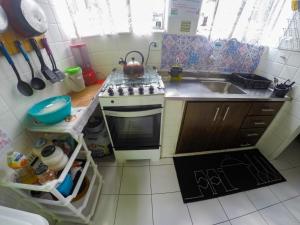 a small kitchen with a stove and a sink at Vila Rock Hostel - próximo Allianz Parque, Vila Madalena, Av Paulista, Hospital das Clínicas INCOR FMUSP in São Paulo