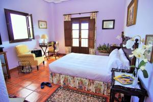 een slaapkamer met een bed, een stoel en een raam bij Nuevespigas in Casarabonela