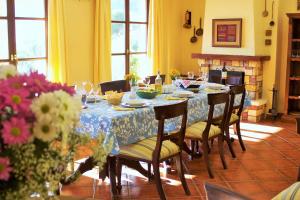- une salle à manger avec une table, des chaises et des fleurs dans l'établissement Nuevespigas, à Casarabonela