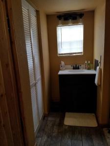 La salle de bains est pourvue d'un lavabo et d'une fenêtre. dans l'établissement Cabin Sweet Cabin, à Canyon Lake