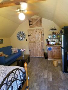 a living room with a blue couch and a wooden door at Cabin Sweet Cabin in Canyon Lake