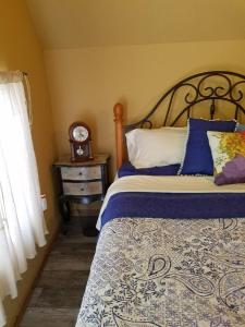 a bedroom with a bed and a clock on a table at Cabin Sweet Cabin in Canyon Lake