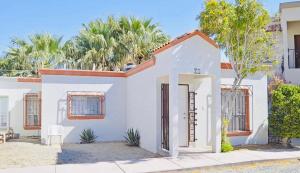 una casa blanca con una puerta y árboles en Villa in Tranquil Gated Community, 2 Bedroom 2 Bath, en Puerto Peñasco