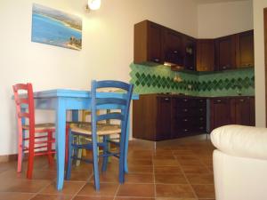 cocina con mesa azul y 2 sillas en Oleandro en Lotzorai
