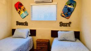 zwei Einzelbetten in einem Schlafzimmer mit Fenster in der Unterkunft Condo de Cortez in Puerto Peñasco + 16 Fotos