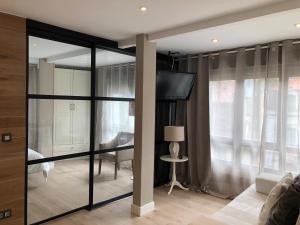 a living room with sliding glass doors and a tv at Apartamentos Las Vegas in Ribadesella