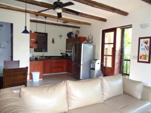 salon z białą kanapą i kuchnią w obiekcie Casa Sonrisas w mieście Playa del Carmen