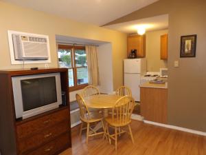uma cozinha e sala de jantar com uma mesa e uma televisão em The Villas on Lake George em Diamond Point