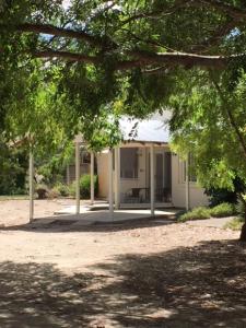 a white house with a porch and a tree at Mapperley Bed and Breakfast in Bordertown